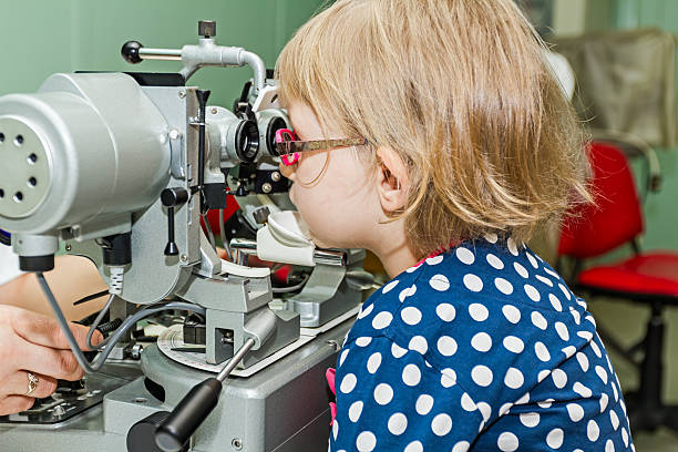 a looking child learning how to use an ophthalmoscope.